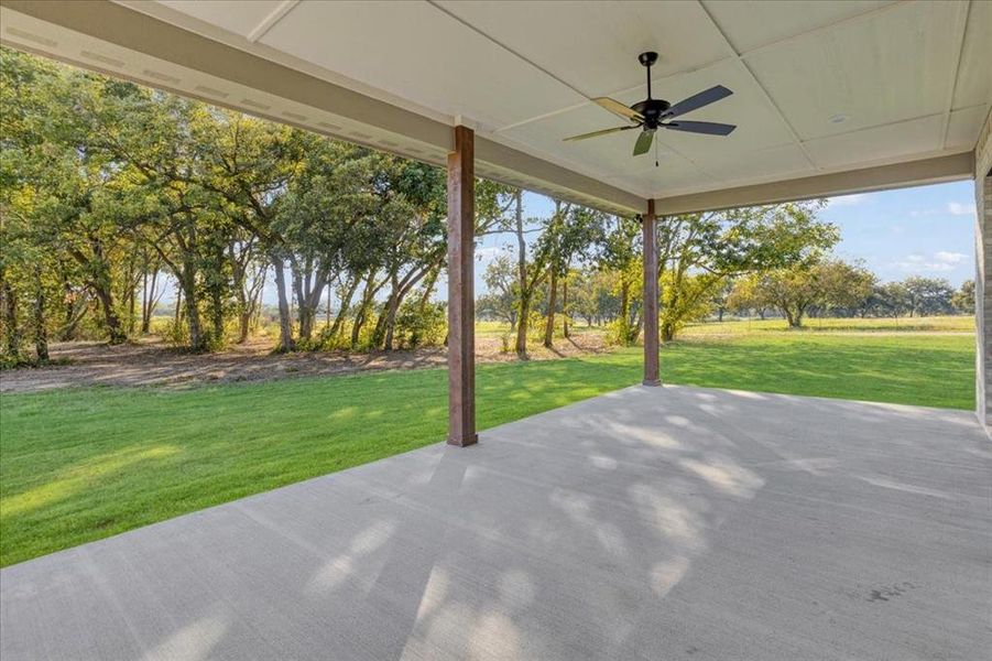 The expansive back covered patio has a pretty hardwood tree line view. The expansive back covered patio has a pretty hardwood tree line view.