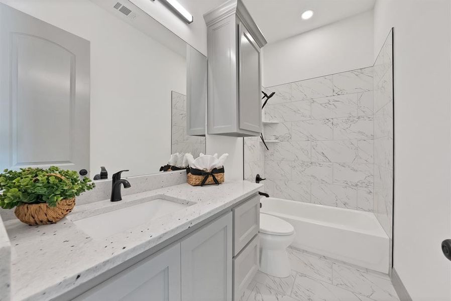 Full bathroom featuring shower / bath combination, vanity, and light marble finish floors