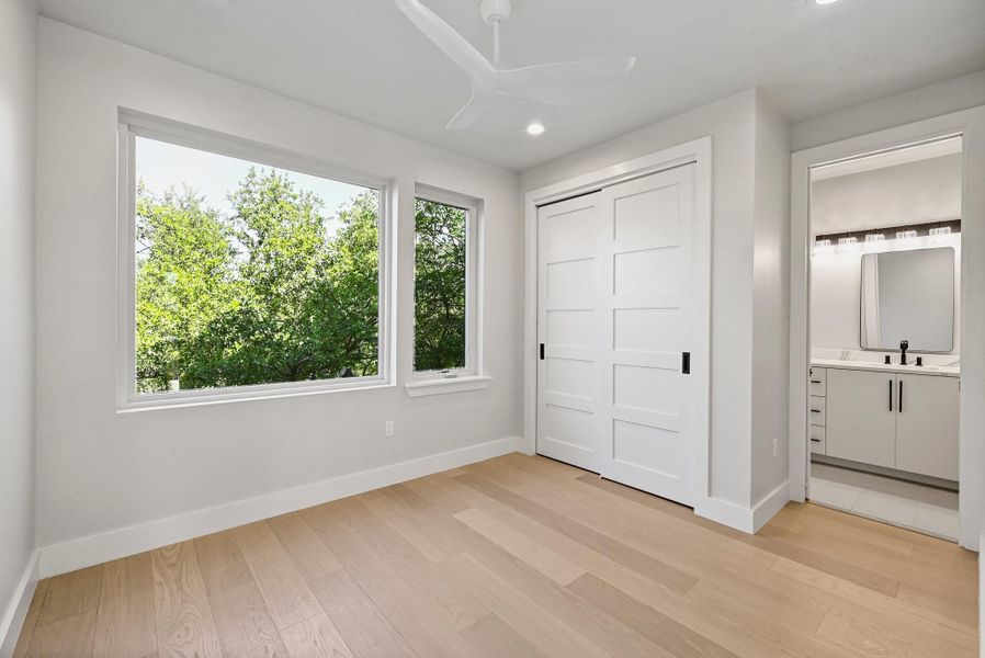 3rd Floor Secondary Bedroom with connected Bathroom. (This is Unit #2 - each Unit has the same layout, however a few differing details such as light fixtures, custom cabinet/backsplash/tile colors)