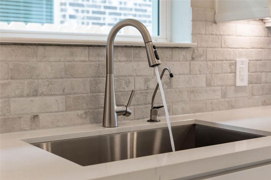 The kitchen features a stainless steel undermount sink and a Moen Sleek stainless steel kitchen faucet with DuPure water filtration system.