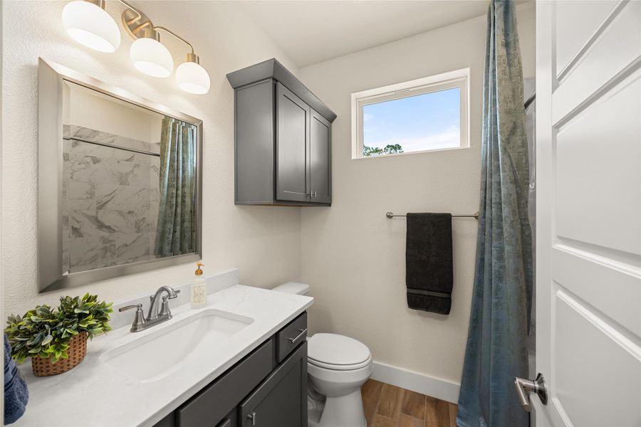 Bathroom featuring vanity, a shower with shower curtain, and dark wood-style floors