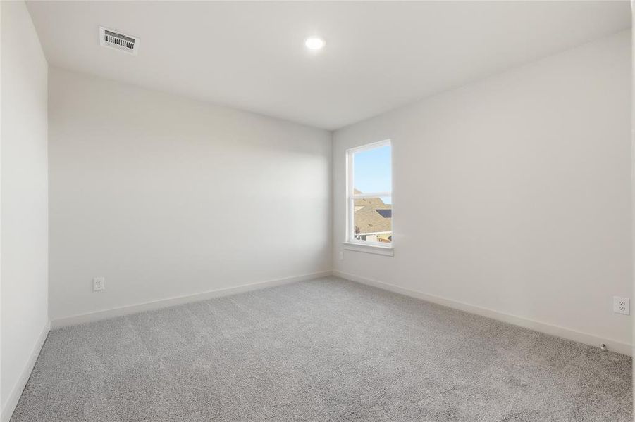 Neutral-toned room featuring light gray carpeting, white baseboards, and a single window offering exterior views Neutral-toned room featuring light gray carpeting, white baseboards, and a single window offering exterior views