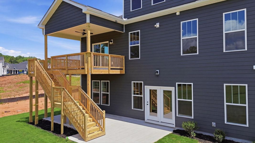 Rear covered porch and deck creates a seamless extension of this home’s elegant design by DRB Homes