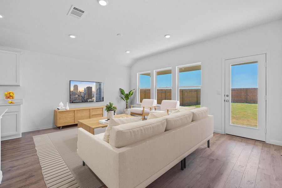 Living room with dark wood-style flooring, recessed lighting, and vaulted ceiling