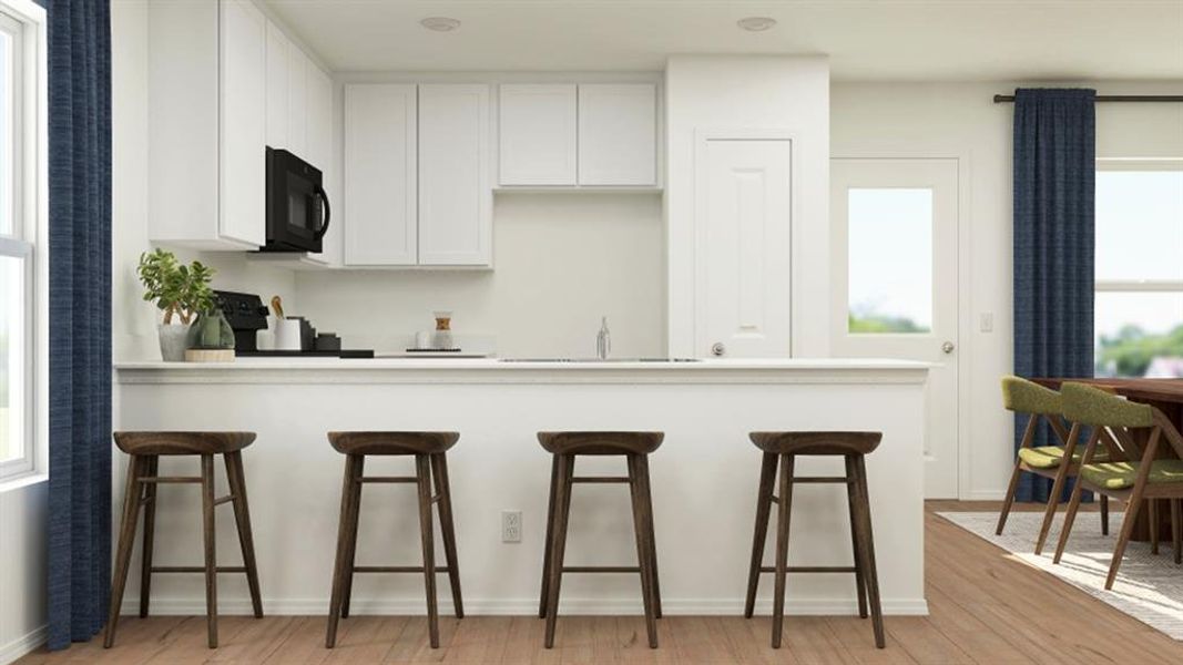 Kitchen featuring a kitchen breakfast bar, white cabinetry, a sink, and black appliances