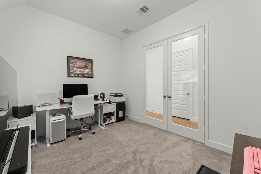 Another view of the study highlights elegant French doors, offering privacy and sound control while maintaining visual connection to the main living areas of the home. There are two large closets right across the hall for every day storage.