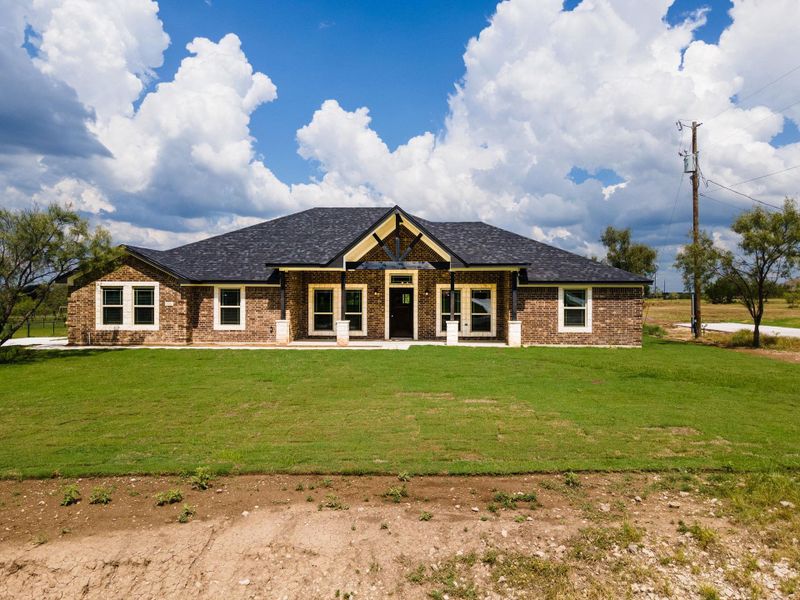 View of front of property with brick veneer, a front lawn, roof with shingles, and covered porch View of front of property with brick veneer, a front lawn, roof with shingles, and covered porch