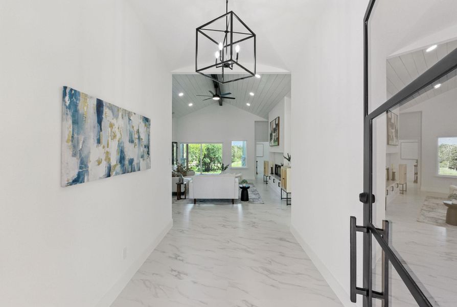 Hallway with light tile finish floors,  and a chandelier