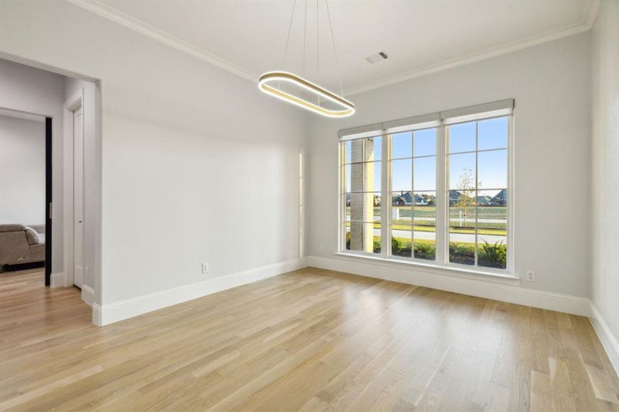 Dining room with designer light fixture has plenty of space during special occassions