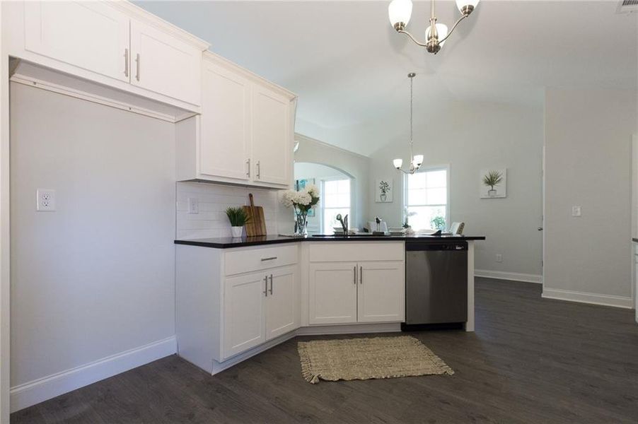 Kitchen featuring dark hardwood / wood-style flooring, a notable chandelier, dishwasher, and decorative light fixtures