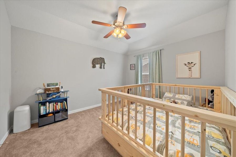 Carpeted Bedroom 2 with ceiling fan and lofted ceiling.