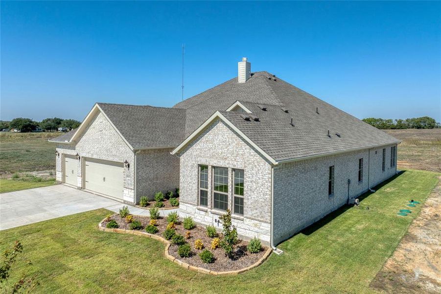 View of side of property featuring a garage and a lawn