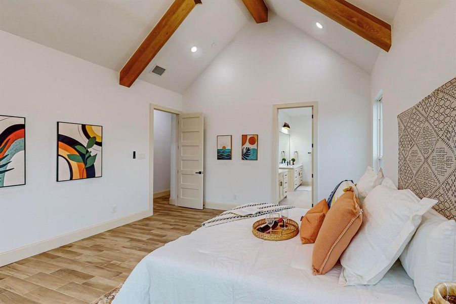 Bedroom with high vaulted ceiling, light hardwood / wood-style floors, beamed ceiling, and ensuite bath