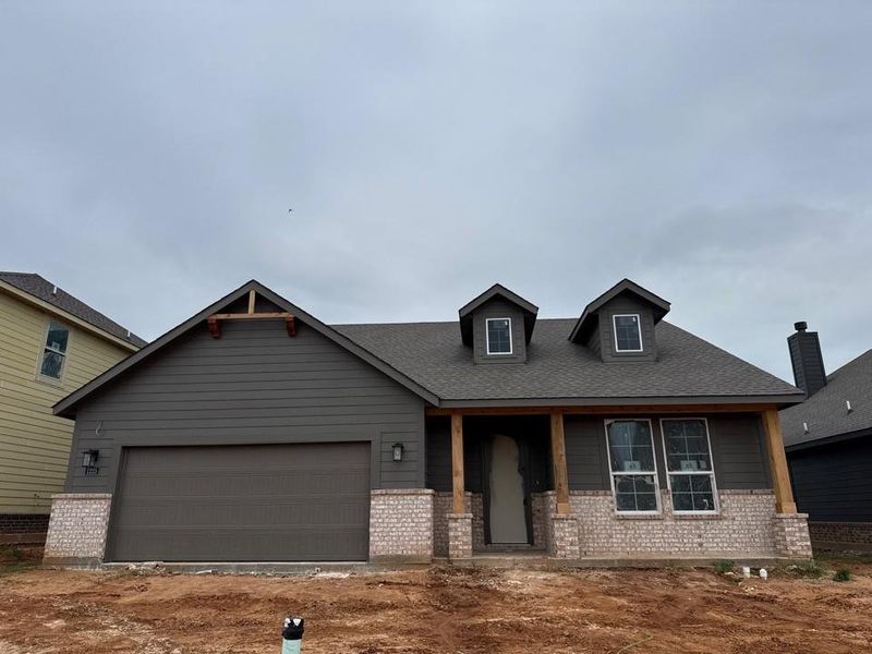 Newly constructed residence featuring a dark gray siding exterior with white brick accents