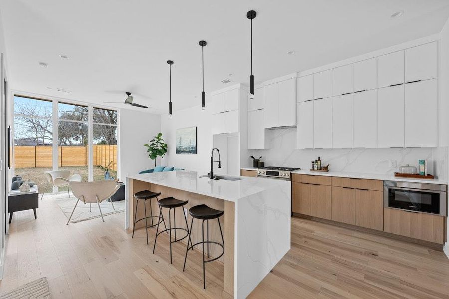 Kitchen featuring white cabinets, floor to ceiling windows, modern cabinets, and light wood-style floors