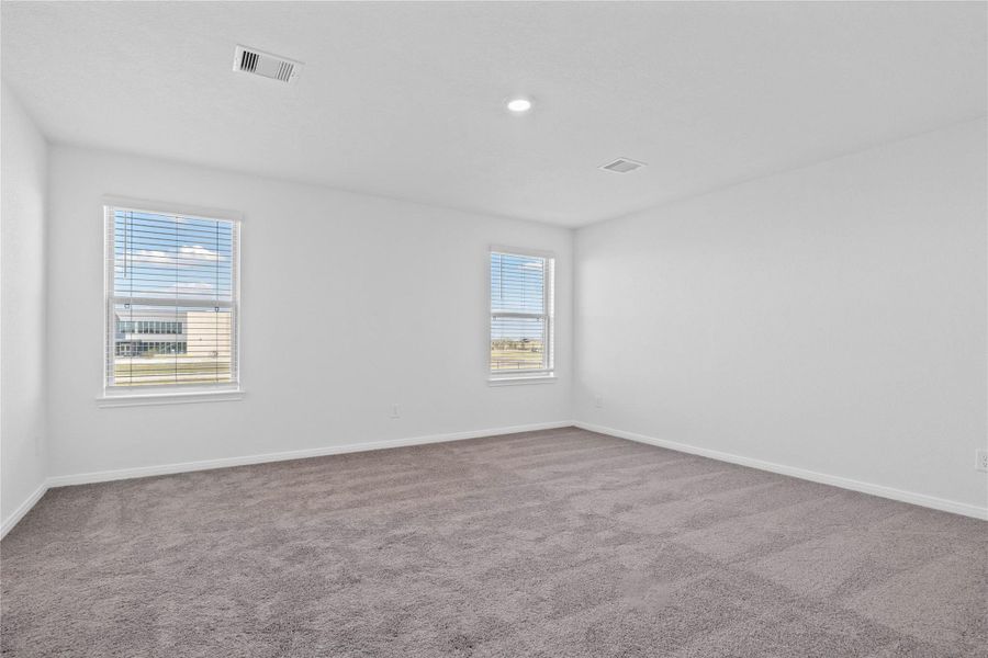 Relax and recharge in this stunning primary suite! This expansive room offers plush carpeting, neutral-toned walls, high ceilings, recessed lighting, and large windows with blinds—perfect for unwinding after a long day.