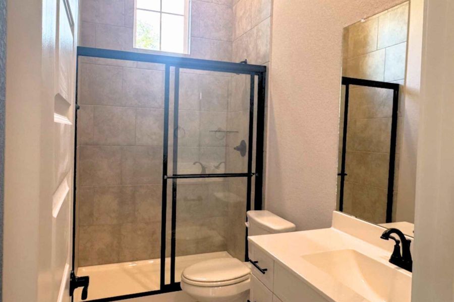 Full bathroom with vanity, a shower stall, and a textured wall Full bathroom with vanity, a shower stall, and a textured wall