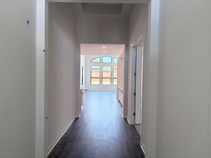 Long hallway entrance with dark hardwood flooring creates a welcoming flow into the main living space. Long hallway entrance with dark hardwood flooring creates a welcoming flow into the main living space.