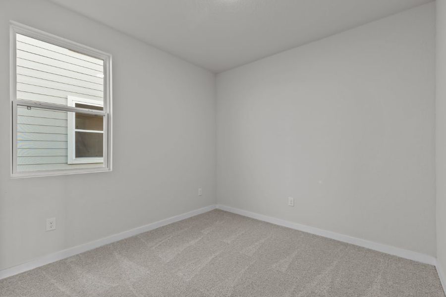 A room with a window and a carpet.