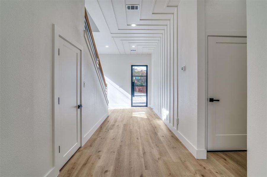 Hall with light wood-type flooring and recessed lighting