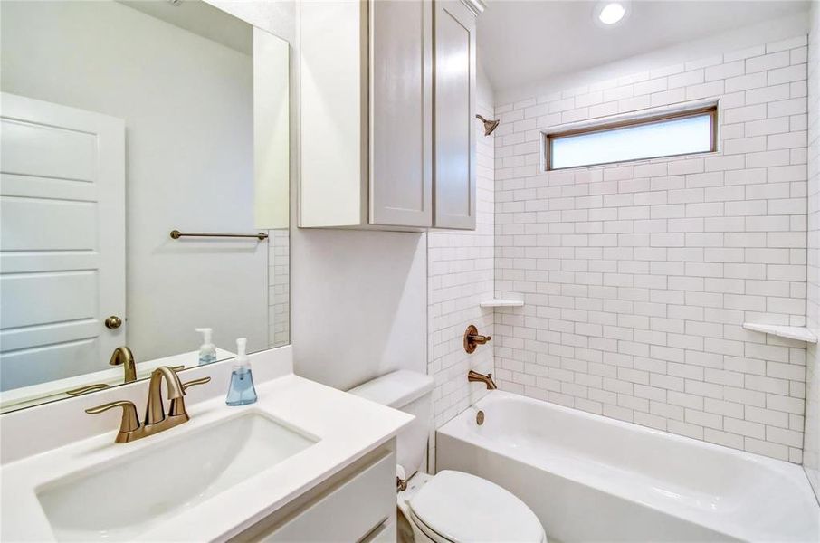 Full bathroom with vanity, toilet, and tiled shower / bath combo