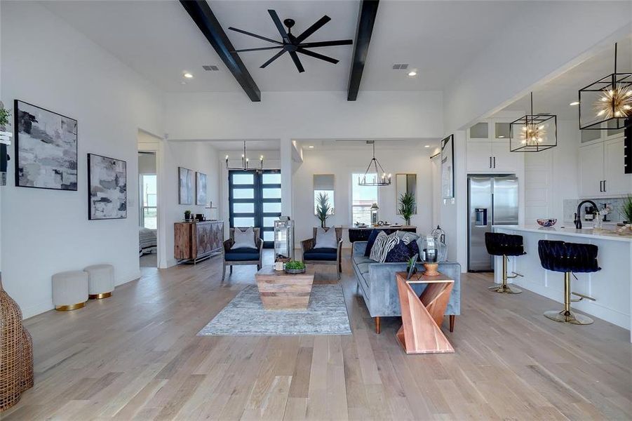 Living area with a chandelier, light wood-style flooring, beamed ceiling, recessed lighting, and ceiling fan