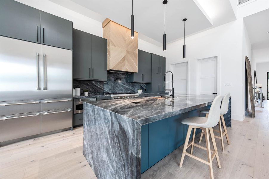 Custom cabinetry and island with striking quartzite waterfall countertops. combining functionality and modern luxury.