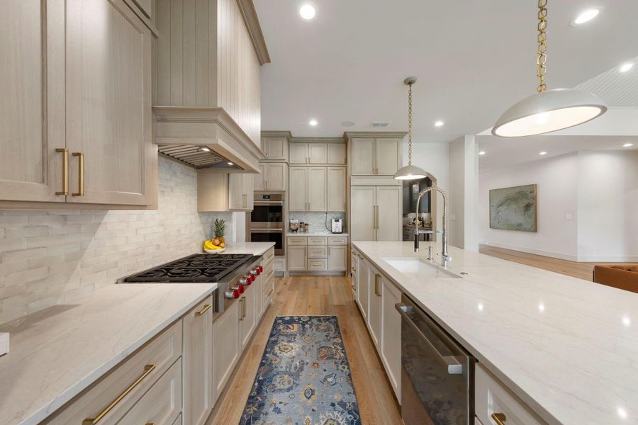 Gourmet kitchen featuring Wolf appliances and a Sub-Zero built-in refrigerator, custom cabinetry, a spacious island with prep sink, and elegant finishes designed for both everyday cooking and entertaining.