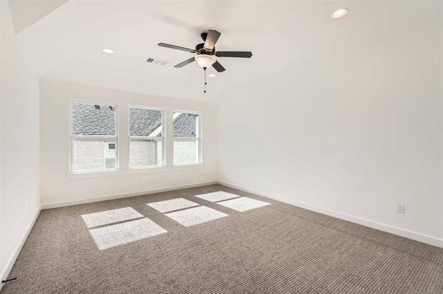 Carpeted spare room with ceiling fan