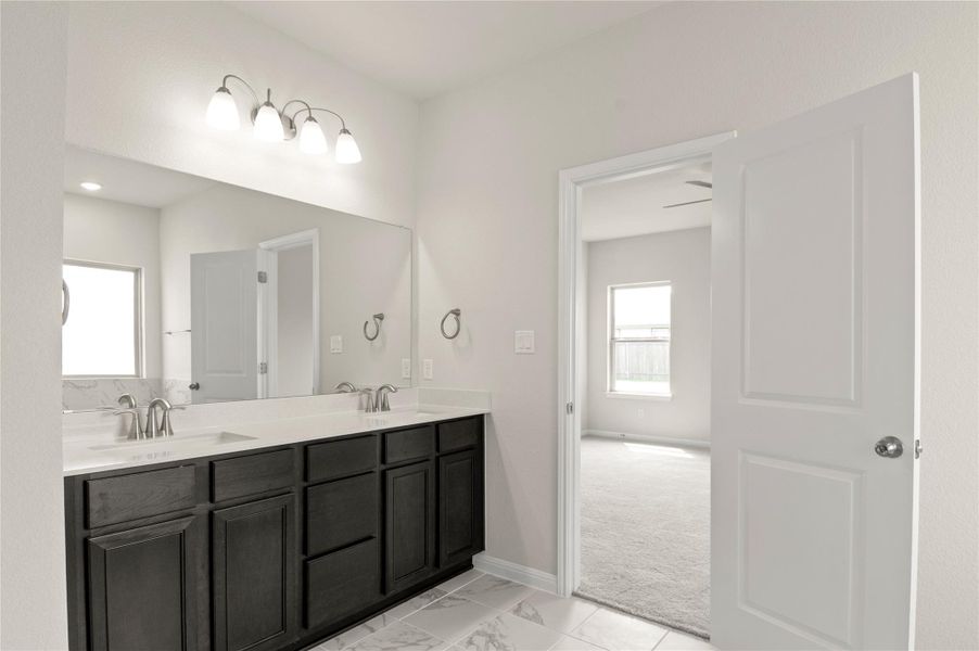 Full bathroom featuring double vanity and marble finish floors