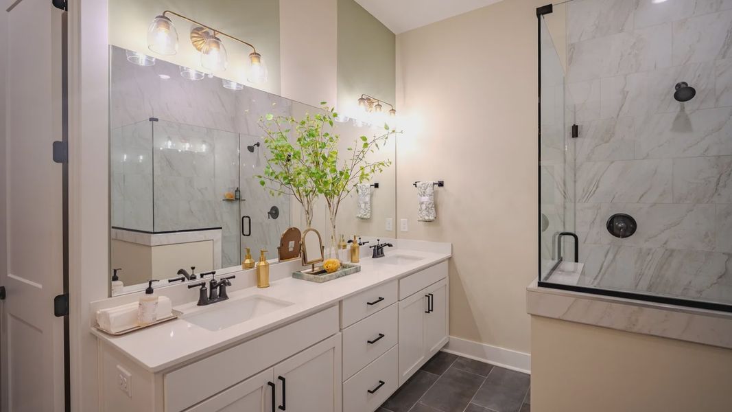 Primary bathroom with dual vanity and glass enclosed shower Primary bathroom with dual vanity and glass enclosed shower