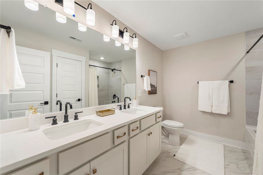 This sleek bathroom features a double vanity and a