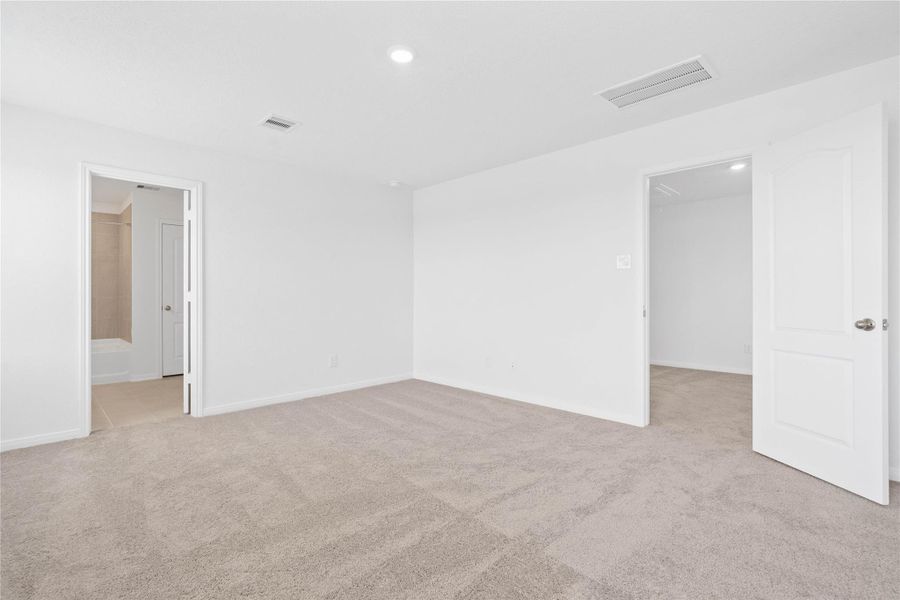 Additional view from the primary bedroom into the primary bathroom. Additional view from the primary bedroom into the primary bathroom.