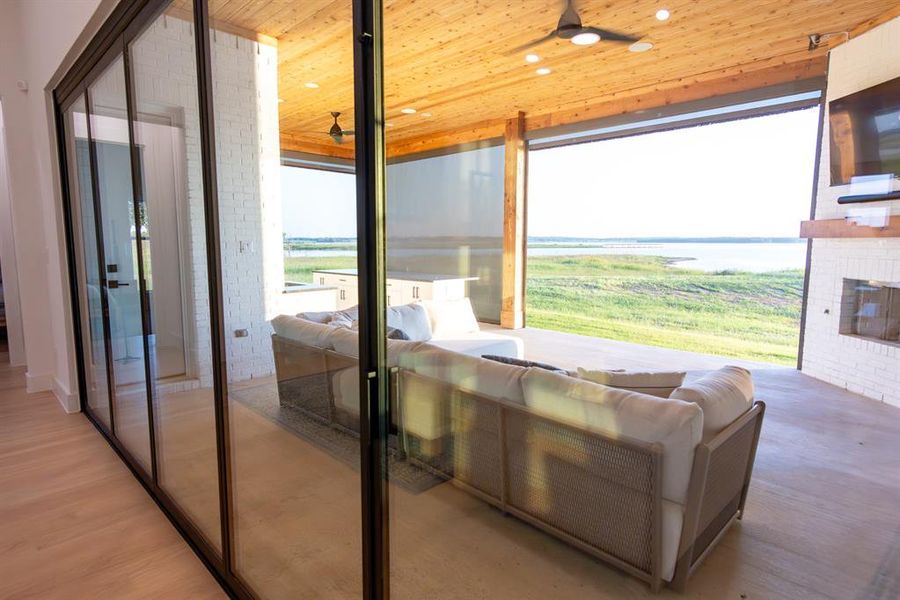 Doorway featuring ceiling fan, wood ceiling, wood finished floors, and a fireplace Doorway featuring ceiling fan, wood ceiling, wood finished floors, and a fireplace
