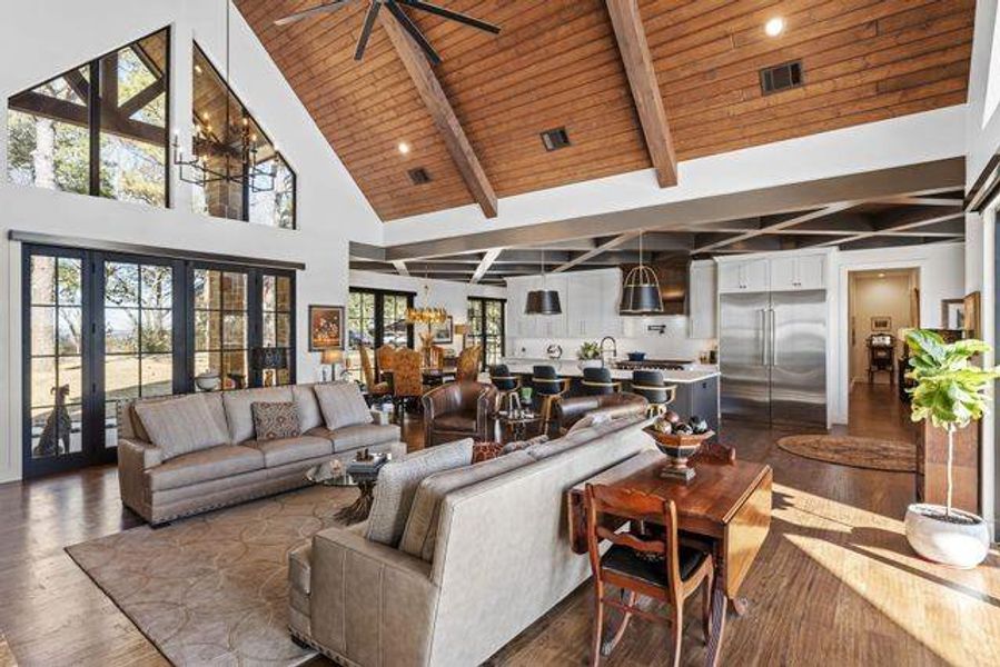 Living area with high vaulted ceiling, dark wood-type flooring, and a wooden ceiling with exposed beams