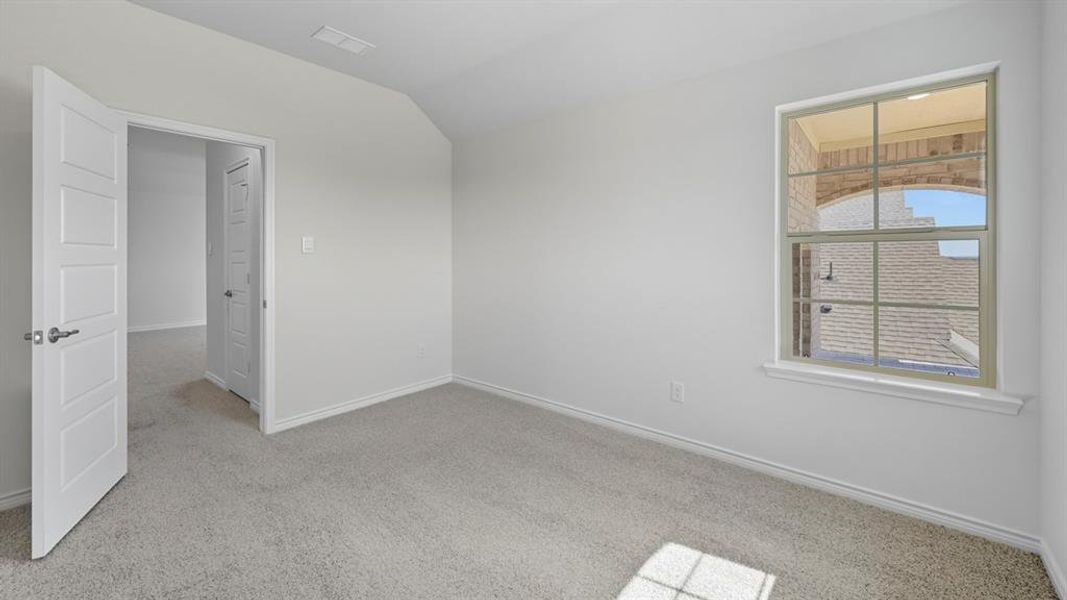 Unfurnished room featuring light carpet and vaulted ceiling Unfurnished room featuring light carpet and vaulted ceiling