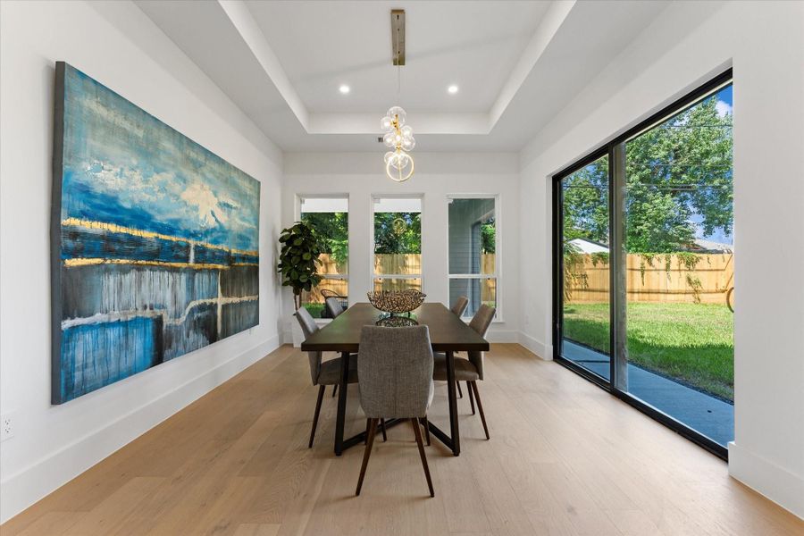 Bright and contemporary dining area featuring ample natural light from windows and glass doors that open to a fenced backyard and back patio, creating an inviting space for gatherings. With room for a pool, you can eat while admiring the light reflecting on the water. Bright and contemporary dining area featuring ample natural light from windows and glass doors that open to a fenced backyard and back patio, creating an inviting space for gatherings. With room for a pool, you can eat while admiring the light reflecting on the water.