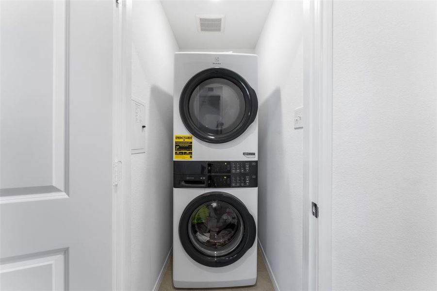 Laundry room featuring estacked washer and dryer and baseboards Laundry room featuring estacked washer and dryer and baseboards