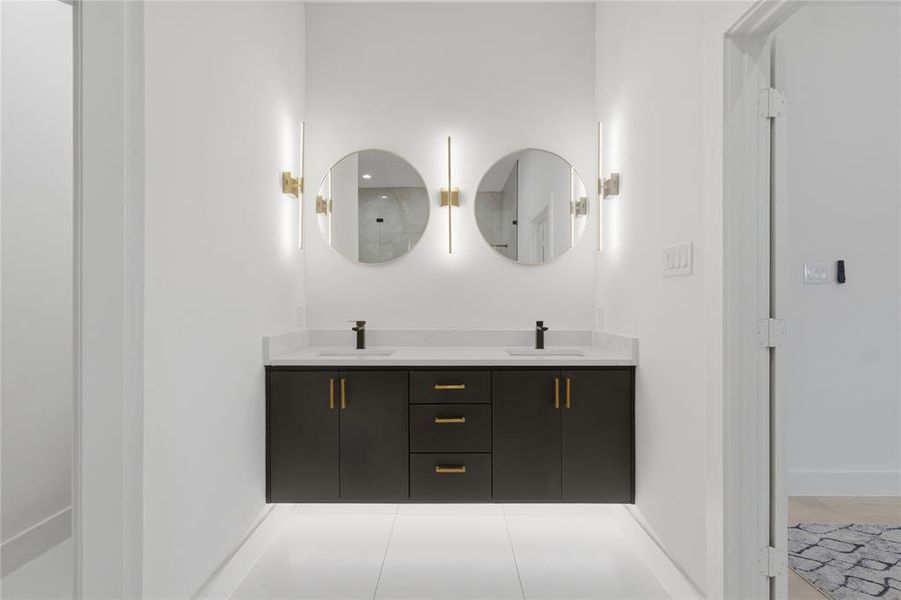 Bathroom featuring double vanity and baseboards Bathroom featuring double vanity and baseboards
