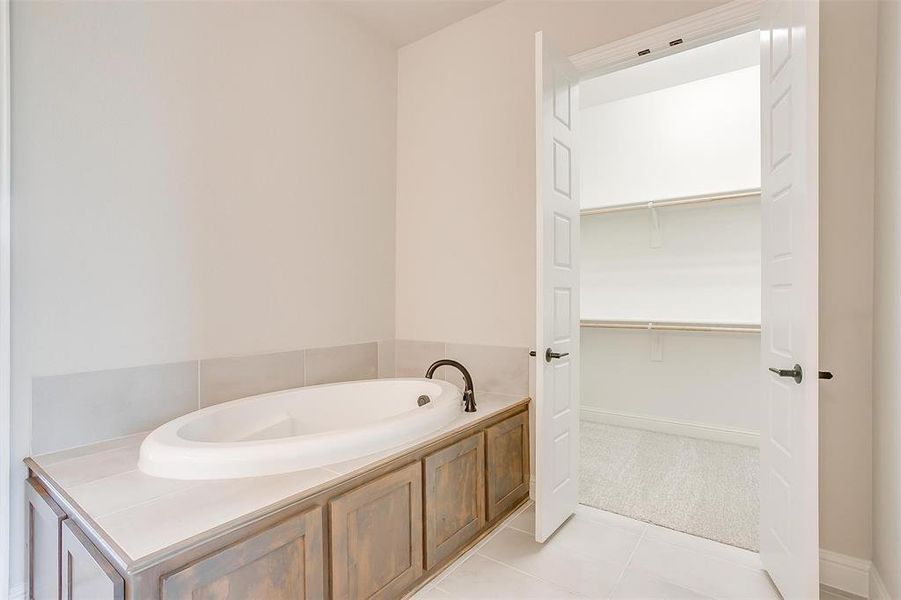 Bathroom featuring a tub to relax in and tile patterned floors