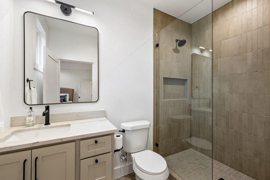 A well-appointed bath features a spacious glass-enclosed shower with tiled walls and a modern vanity. A well-appointed bath features a spacious glass-enclosed shower with tiled walls and a modern vanity.