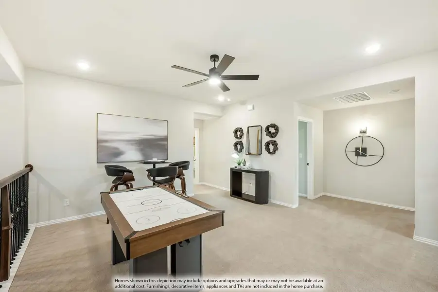 Upstairs game room with air hockey table, ceiling fan, and carpet flooring near staircase railing
