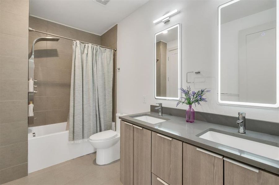 Full bathroom with shower / tub combo, tile patterned flooring, vanity, and toilet