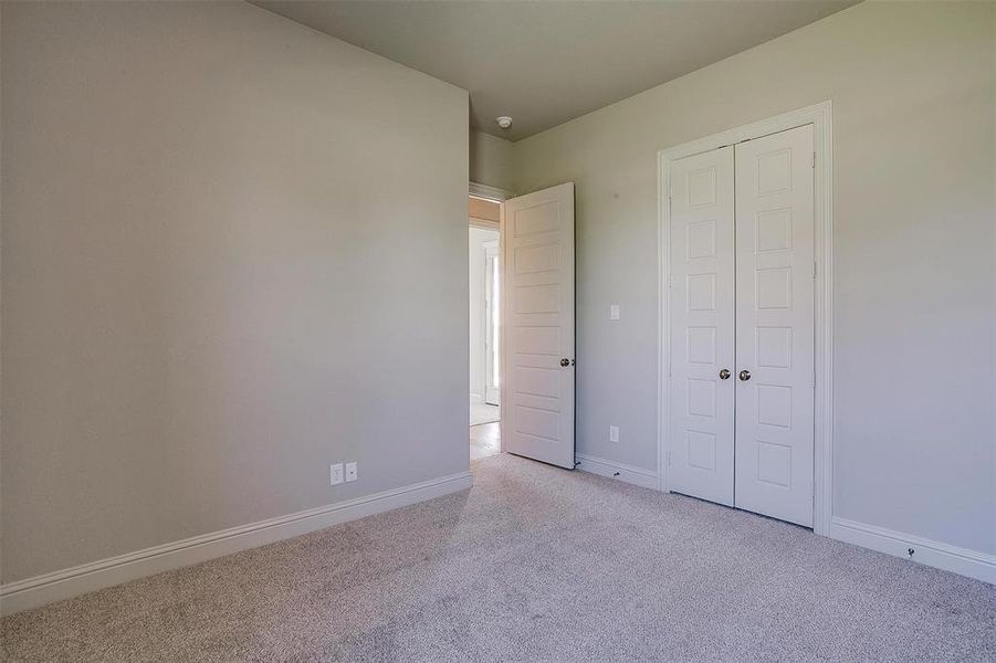 Unfurnished bedroom with a closet and light carpet