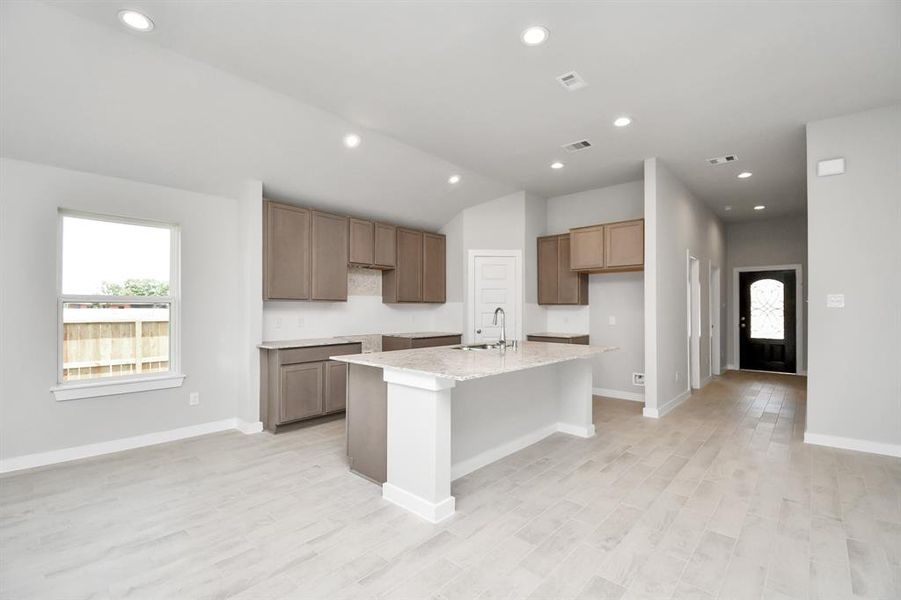 Culinary haven, featuring granite countertops, a tile backsplash, stainless steel appliances (to be installed), and 42” upper cabinets.  Sample photo of completed home with similar floor plan. Actual colors and selections may vary.