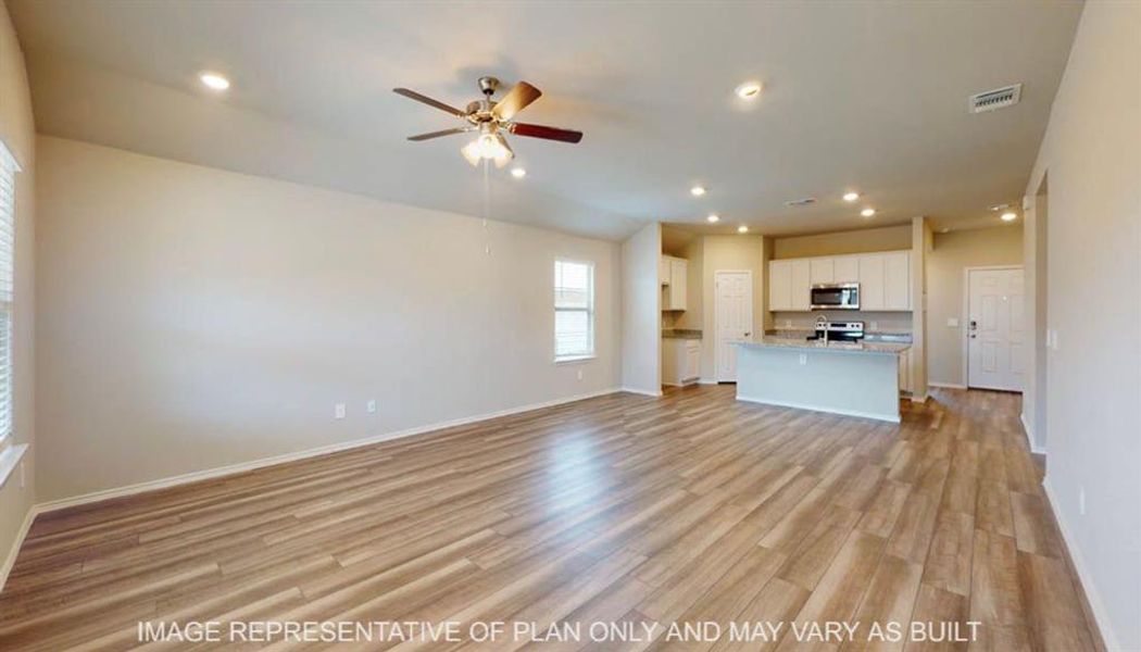 Open-concept living area with wood-finish flooring, recessed lighting, and a ceiling fan