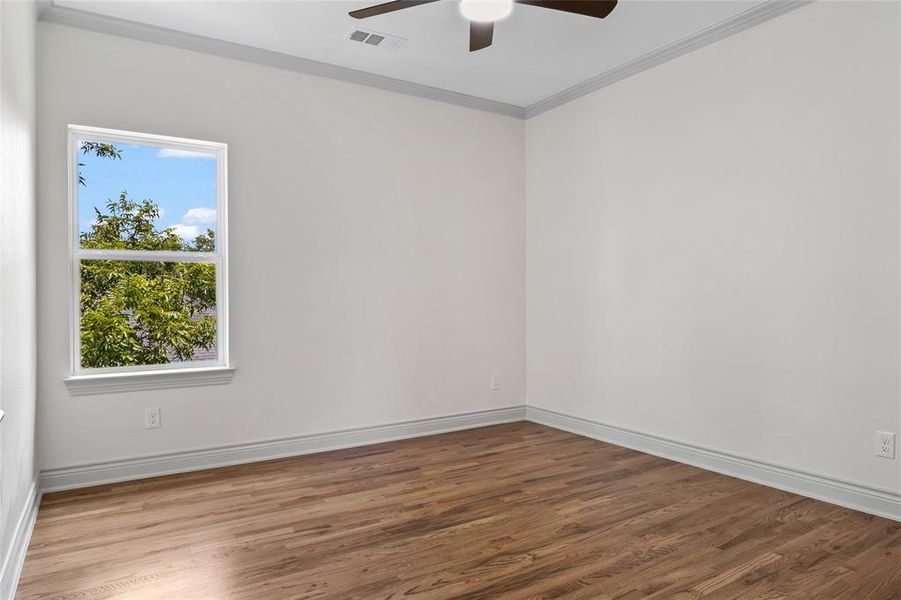 Crown molding, wood finished floors, and ceiling fan Crown molding, wood finished floors, and ceiling fan