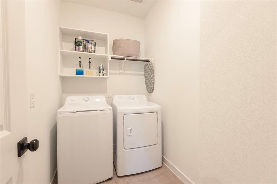 Dedicated laundry area featuring white walls, open shelving, and a built-in hanging rod Dedicated laundry area featuring white walls, open shelving, and a built-in hanging rod