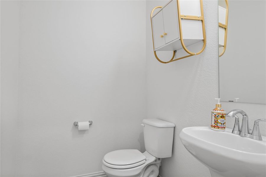 A well-appointed powder room features a sleek vanity and convenient wall-mounted storage, reflecting modern design. A well-appointed powder room features a sleek vanity and convenient wall-mounted storage, reflecting modern design.