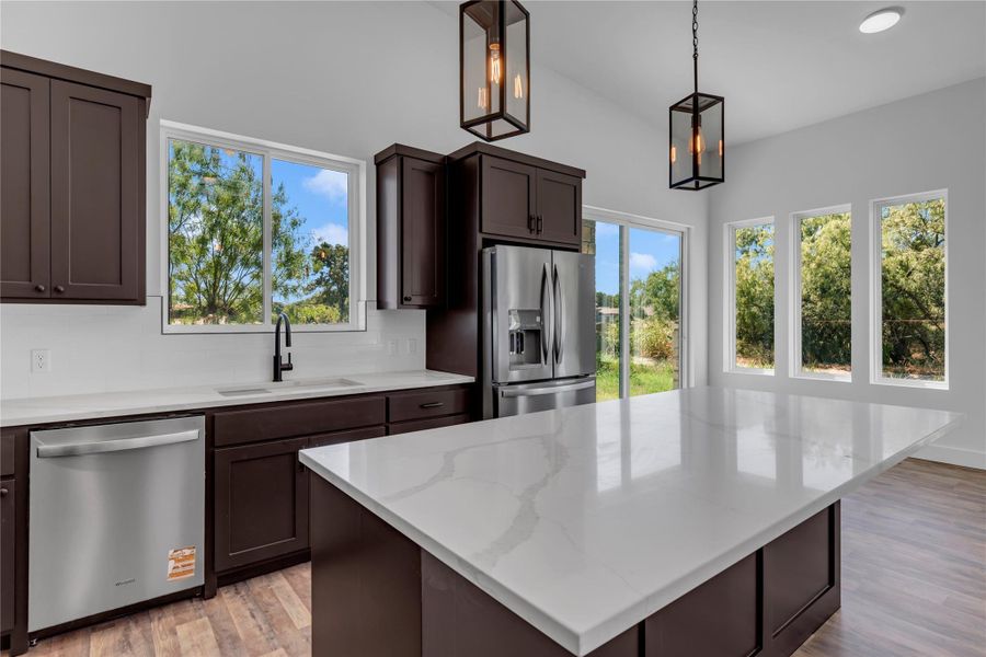 Rich dark cabinetry contrasts beautifully with pristine stone countertops and modern stainless steel appliances.